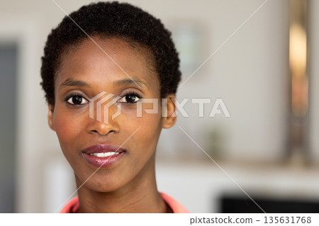 Smiling woman with short hair looking confidently at camera indoors 135631768