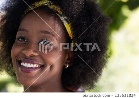 Smiling African American woman outdoors, enjoying sunny day with friends 135631824