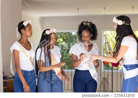 Celebrating friendship, women in matching outfits toasting with champagne at home Celebrating friendship, women in matching outfits toasting with champagne at home 135631850