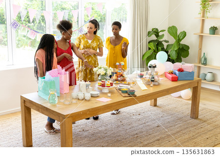 Celebrating birthday, diverse female friends with gifts and decorations at party 135631863