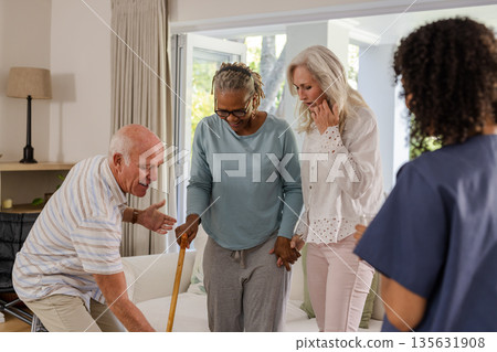 Senior friends supporting each other while African American woman using walking cane Senior friends supporting each other while African American woman using walking cane 135631908