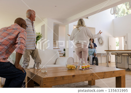 Senior friends gathering at home, joyfully welcoming each other with open arms Senior friends gathering at home, joyfully welcoming each other with open arms 135631995