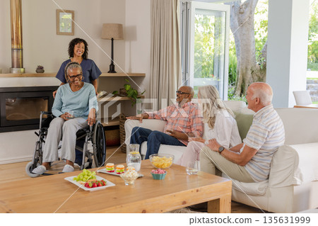 Senior friends enjoying conversation and snacks in cozy living room setting Senior friends enjoying conversation and snacks in cozy living room setting 135631999