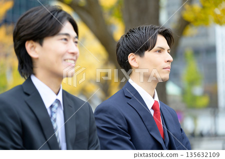 A smiling Japanese man in a suit in an office district A smiling Japanese man in a suit in an office district 135632109