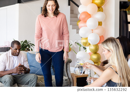 Friends enjoying casual gathering at home with balloons and refreshments Friends enjoying casual gathering at home with balloons and refreshments 135632292