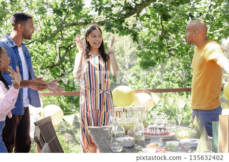 Friends celebrating outdoors with balloons and snacks, enjoying joyful gathering Friends celebrating outdoors with balloons and snacks, enjoying joyful gathering 135632402