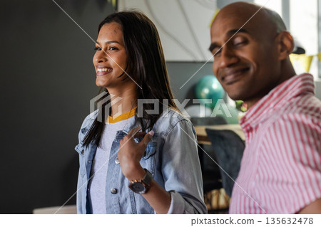 Smiling couple enjoying celebration at home with balloons in background 135632478