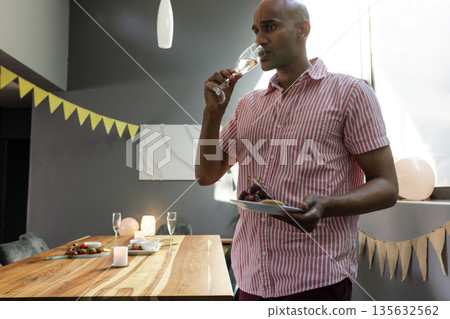 Man enjoying wine and dessert at home during intimate celebration Man enjoying wine and dessert at home during intimate celebration 135632562
