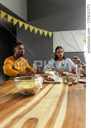 Friends enjoying dinner party with champagne and snacks at home Friends enjoying dinner party with champagne and snacks at home 135632571