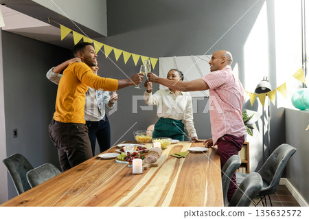 Celebrating joyful occasion, friends toasting with champagne glasses at home together 135632572