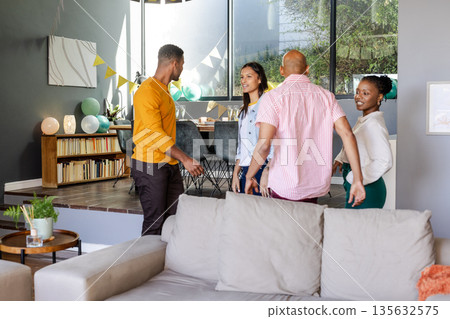 Friends gathering at home, chatting and enjoying casual celebration together 135632575