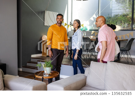 Friends gathering at home, enjoying casual celebration with balloons and decorations 135632585