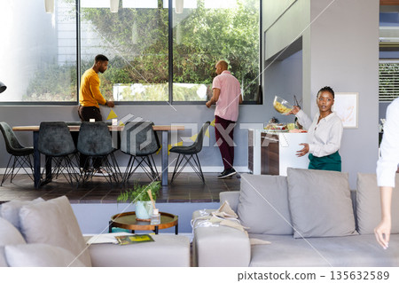People preparing for gathering at home, arranging table and serving food People preparing for gathering at home, arranging table and serving food 135632589