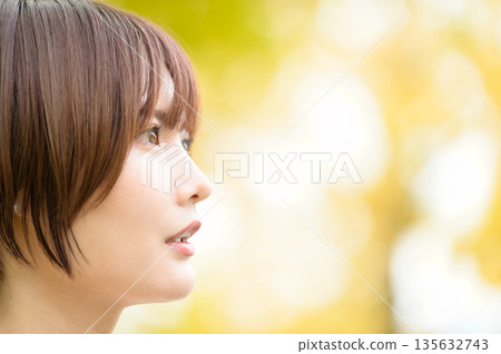 一位女士的側臉，背景是秋葉。 135632743