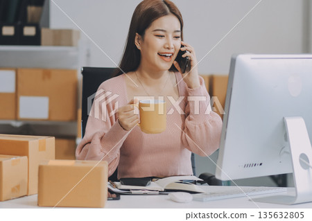 Starting small businesses SME owners female entrepreneurs check online orders to prepare to pack the boxes, sell to customers, sme business ideas online. Starting small businesses SME owners female entrepreneurs check online orders to prepare to pack the boxes, sell to customers, sme business ideas online. 135632805
