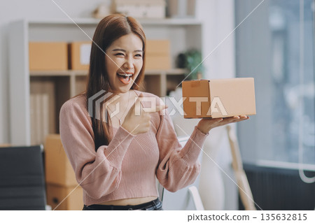 Starting small businesses SME owners female entrepreneurs check online orders to prepare to pack the boxes, sell to customers, sme business ideas online. Starting small businesses SME owners female entrepreneurs check online orders to prepare to pack the boxes, sell to customers, sme business ideas online. 135632815