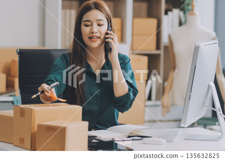 Starting small businesses SME owners female entrepreneurs check online orders to prepare to pack the boxes, sell to customers, sme business ideas online. Starting small businesses SME owners female entrepreneurs check online orders to prepare to pack the boxes, sell to customers, sme business ideas online. 135632825