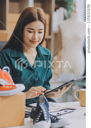 Starting small businesses SME owners female entrepreneurs check online orders to prepare to pack the boxes, sell to customers, sme business ideas online. Starting small businesses SME owners female entrepreneurs check online orders to prepare to pack the boxes, sell to customers, sme business ideas online. 135632836