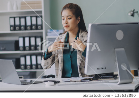 Cheerful business lady working on laptop in office, Asian happy beautiful businesswoman in formal suit work in workplace. Attractive female employee office worker smile. 135632890