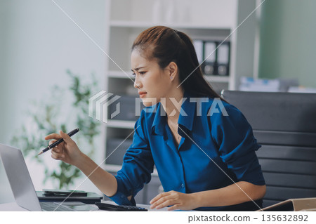 Young businesswoman is holding two credit cards with a worried expression, trying to decide which one to use to pay off her debt Young businesswoman is holding two credit cards with a worried expression, trying to decide which one to use to pay off her debt 135632892