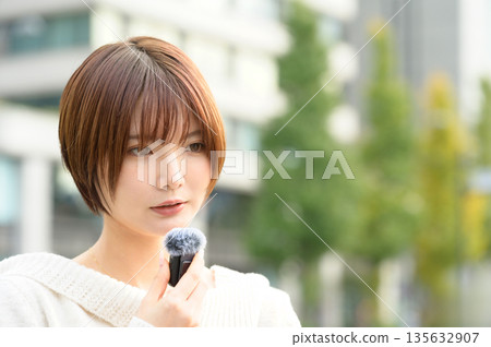 一名短髮女子在辦公區手持別針麥克風 一名短髮女子在辦公區手持別針麥克風 135632907
