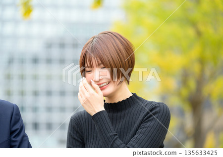 在辦公區,帶著微笑的男女正在交談。 在辦公區,帶著微笑的男女正在交談。 135633425