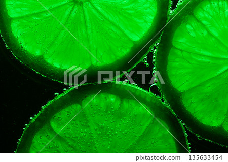 A close up of four green citrus fruits, specifically lime slices A close up of four green citrus fruits, specifically lime slices 135633454