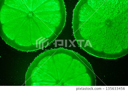 Three green citrus fruit slices with bubbles on the surface Three green citrus fruit slices with bubbles on the surface 135633456