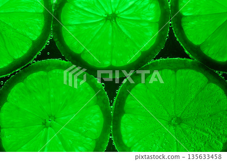 A close up of green citrus fruit, including a lime, with a green background A close up of green citrus fruit, including a lime, with a green background 135633458