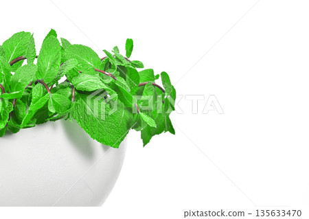 A white bowl with green herbs in it A white bowl with green herbs in it 135633470