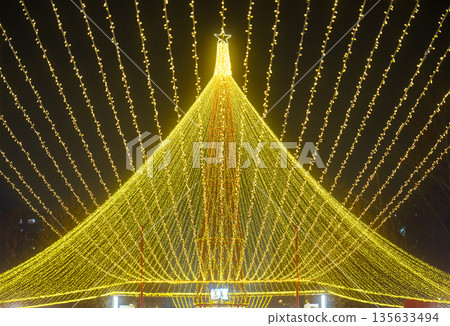 A large Christmas tree with lights is lit up in the night sky A large Christmas tree with lights is lit up in the night sky 135633494
