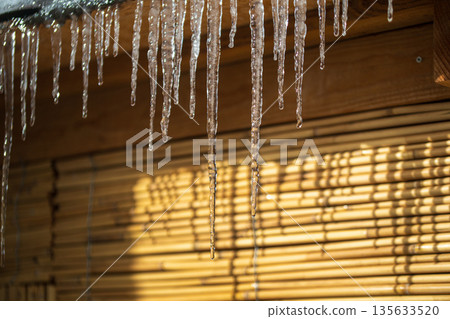 Icicles hanging from a wooden structure 135633520