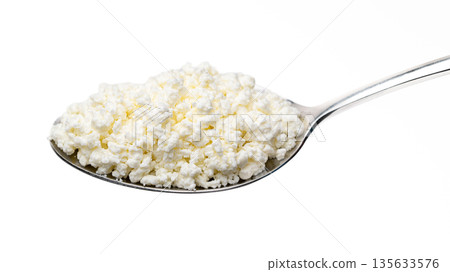 A spoonful of white cheese is shown on a white background A spoonful of white cheese is shown on a white background 135633576