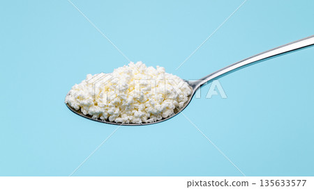 A spoonful of white powder is shown on a blue background A spoonful of white powder is shown on a blue background 135633577