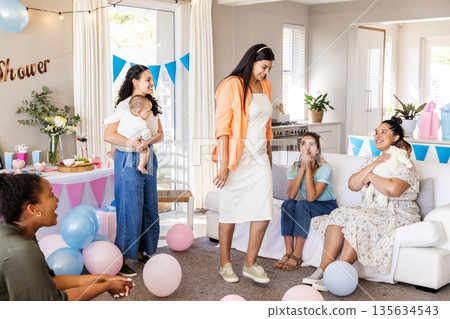 Celebrating baby shower, women sharing joyful moments with balloons and gifts together 135634543