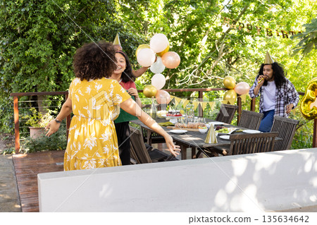 Celebrating birthday outdoors, friends with balloons and cake in festive atmosphere Celebrating birthday outdoors, friends with balloons and cake in festive atmosphere 135634642