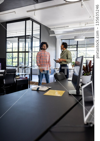 Business professionals discussing project in modern office with digital tablet 135635246
