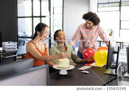 In office, diverse colleagues celebrating birthday with cake and balloons together 135635249
