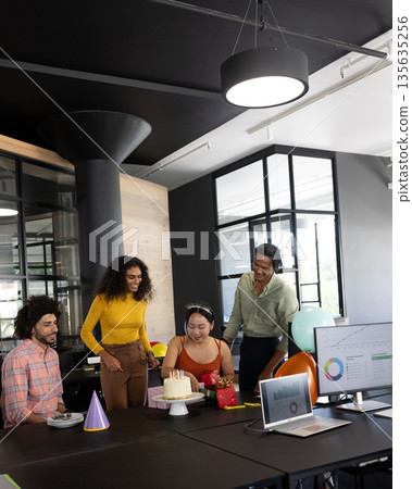 Colleagues celebrating birthday in modern office with cake and decorations 135635256