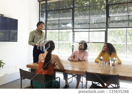 Business meeting in modern office, diverse team discussing new project ideas Business meeting in modern office, diverse team discussing new project ideas 135635266