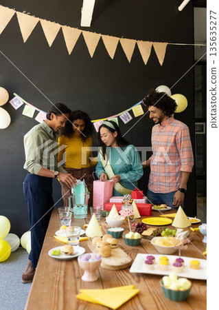 Celebrating birthday with cake and decorations, colleagues in office gathering together 135635277