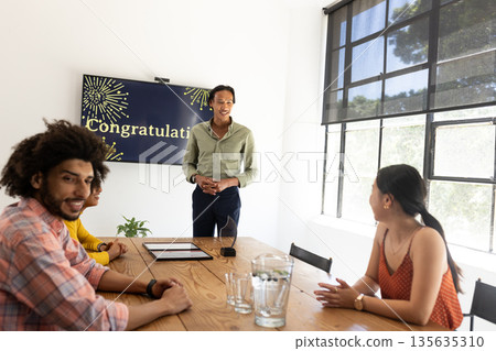 Celebrating success, business team discussing achievements and smiling together in office 135635310