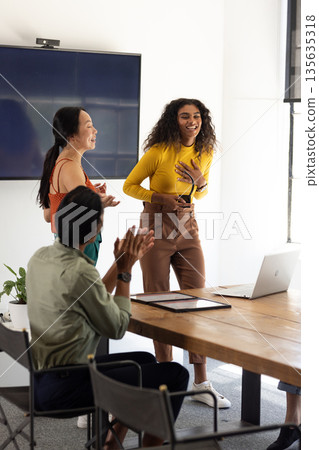 Collaborating in modern office, diverse business team presenting ideas with enthusiasm Collaborating in modern office, diverse business team presenting ideas with enthusiasm 135635318