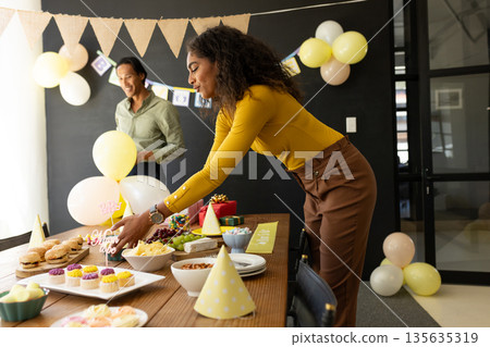 Preparing snacks and decorations, colleagues in office celebrating teamwork together 135635319