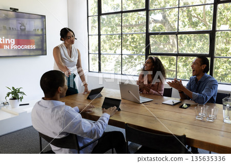 In office, business team discussing ideas, collaborating with laptops and tablets 135635336