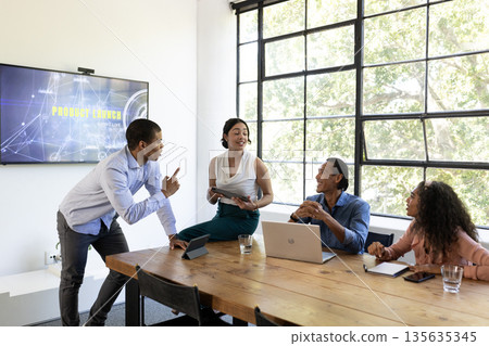 Diverse business team discussing product launch strategy in modern conference room 135635345