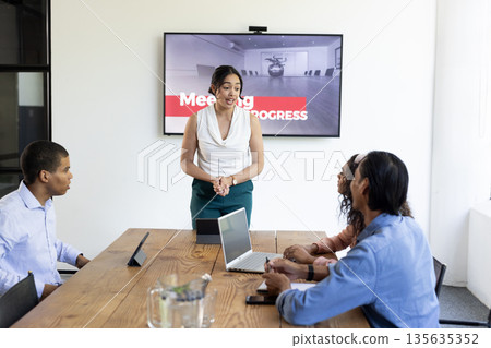 Leading meeting, businesswoman discussing project with diverse team in modern conference room Leading meeting, businesswoman discussing project with diverse team in modern conference room 135635352