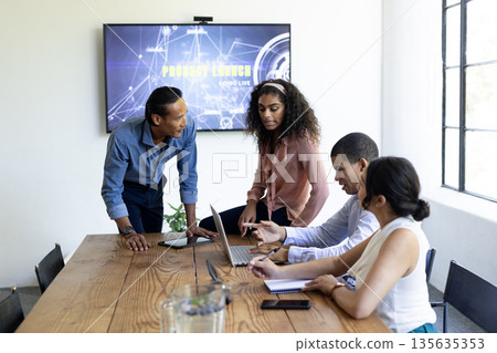 In conference room, diverse business team collaborating on project using laptops 135635353