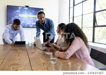 In conference room, business team using digital devices collaborating on project 135635367
