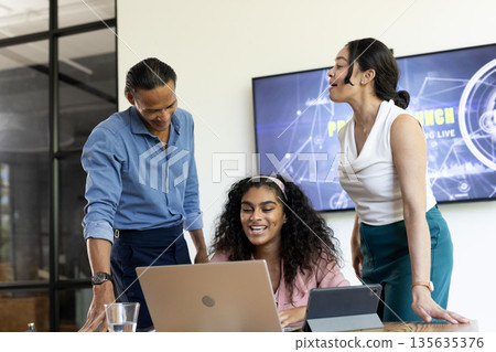 In office, colleagues collaborating with laptop and tablet during business meeting 135635376